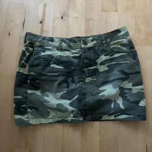 Camoflauge mini jeans kjol - Säljer en grön camo mini kjol med klassiskt camouflage-mönster. Kjolen har fickor både fram och bak samt hällor för bälte. Perfekt för sommaren och i nyskick, hör av er vid frågor❤️