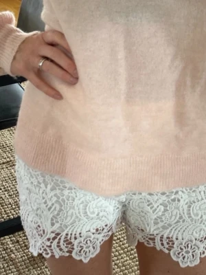 Vita spets-shorts med blommönster - Säljer ett par vita shorts med vacker spets. Shortsen har fina volangdetaljer längst ner. Jättefina till sommaren! (Lånade bilder) kom med bud!💗