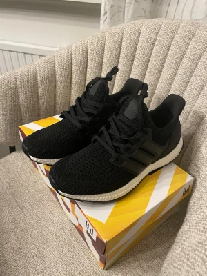 Adidas Ultraboost svarta sneakers - Säljer ett par svarta Adidas Ultraboost sneakers med stickad ovandel och vita Boost-sulor. Aldrig använda 