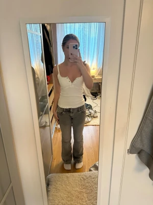 Grå bootcut jeans med låg midja - Säljer ett par grå bootcut jeans med låg midja. Jeansen har femficksdesign och är tillverkade i ett mjukt denimtyg. Perfekta för en avslappnad look. 