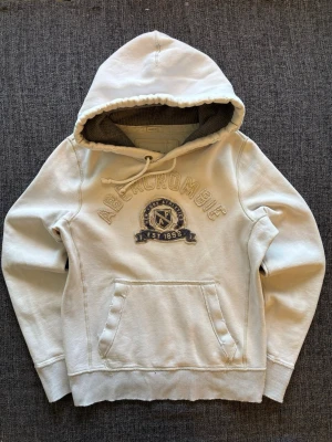 Abercrombie & fitch hoodie ~ vintage  - Sjukt eftertraktad Abercrombie & Fitch hoodie ~ sällsynt 2000’s modell som inte längre produceras | st M/true size | Rekomenderad längd mellan 174–184cm | färg vit | sliten design | klassisk passform | OBS kan gå ner lite i pris vid snabb affär! 🏄
