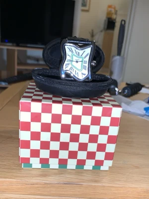 Laphton. square melting - Har haft den på mig i 2 veckor har börjat med löpning och träning använder istället nu Apple Watch dagligen den har nu bara legat senaste 4 månader hemma därför vill jag sälja den allt funkar med den som det ska inga skador eller repor Säljer en unik klocka inspirerad av Salvador Dalí med böjd, silverfärgad urtavla och romerska siffror. Klockan har ett svart band i skinn med struktur och klassiskt spänne. Perfekt för dig som gillar konstnärliga accessoarer. 