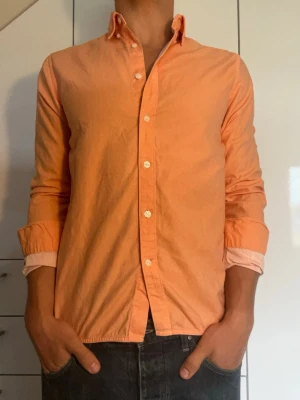 Orange skjorta - Orange skjorta från East West i strl S tillverkad i 100% bomull. Inga defekter. Modellen är 178 cm och väger 77 kg. Hör gärna av dig vid frågor!