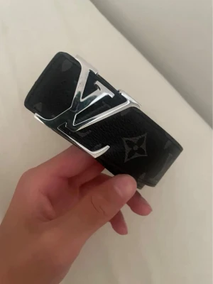 Svart L bälte - En svart bälte med massa symboler runt om, materialet är läder och bältet är size 110|40.