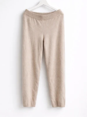 Beige stickade loungebyxor - Mysiga beige stickade loungebyxor med hög midja och bred resår i midjan. Byxorna har raka ben och ribbade muddar vid bensluten. Perfekta för hemmamys eller avslappnade dagar. Materialet känns mjukt och stretchigt, vilket ger en skön passform.