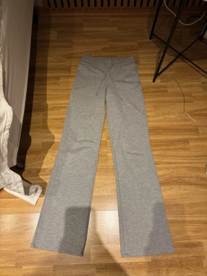 Grå mjukisbyxor med raka ben - Säljer ett par grå mjukisbyxor med raka ben. Byxorna är  i mjukt och stretchigt material som känns skönt mot huden. Söker för att jag har två par:)