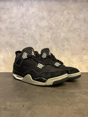 Air Jordan 4 Retro Black Canvas - Säljer ett par svarta Air Jordan 4 Retro Black Canvas med meshpaneler, grå detaljer och vit sula. Perfekta för dig som gillar streetwear och vill ha en tidlös look. I använt skick som lite vanligt slitage (se bild) men okej skick överlag! Nypris ca 4000:- 