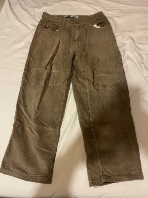 Bruna manchesterbyxor från Polar Skate Co - Säljer ett par bruna manchesterbyxor från Polar Skate Co med raka ben och klassisk femficksdesign. Byxorna har breda revärer och en liten broderad patch på fickan fram. Perfekta för dig som gillar streetwear och skön passform.