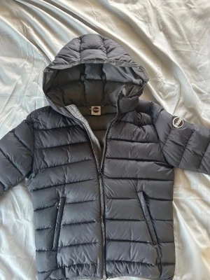 Mörkgrå pufferjacka från Colmar - Snygg mörkgrå/svart pufferjacka från Colmar med huva och dragkedja framtill. Några defekter, skriv för frågor💕