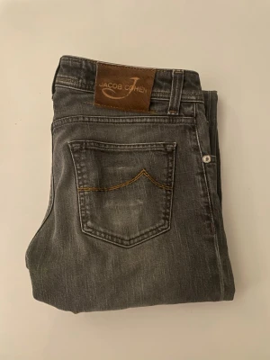 Jacob Cohën Jeans  - Produkt: Jacob Cohen Jeans  Färg: Svart/Grå Storlek: 31 Nypris: Över 5 000 kr  Detaljer: *   Klassisk tvätt *   Diskret Jacob Cohen-logga på bakfickorna *   Längd: ca 103 cm *   Midjebredd: ca 41 cm *   Passform: Slim/Rak *   Modell: 620  Skick: Mycket bra.                                               Snabb frakt, inom 24 timmar.  Priset kan diskuteras vid snabb affär.