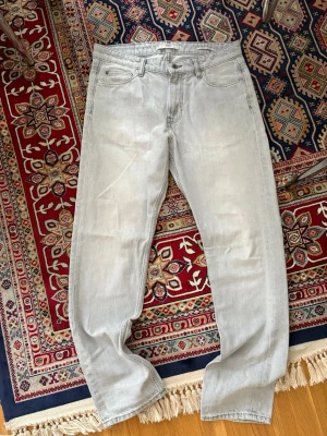 Ljusgrå raka jeans - Säljer ett par ljusgrå jeans med rak passform och klassisk femficksdesign. 