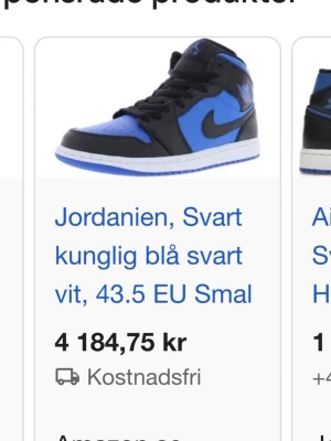 Air Jordan 1 svart/blå sneaker - Snygga Air Jordan 1 sneakers i svart och kungligt blått med vita detaljer. Klassisk high-top siluett med ikonisk swoosh på sidan och blå yttersula. Perfekta för dig som vill sticka ut med stilrena färgblock och retrovibe.