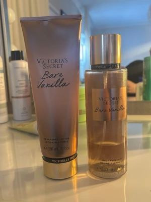 Victoria's Secret Bare Vanilla parfym - Victoria's Secret Bare Vanilla parfymset med en doftmist och en matchande lotion. Båda har en elegant guldig och beige design med svarta detaljer. Doften är söt och varm med tydliga vaniljtoner. Perfekt för dig som gillar mjuka och krämiga dofter. Du ser hur mkt spray som är kvar och ca 60% av lotion är kvar 