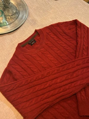 Kabelstickad Massimo Dutti - Snygg Kashmir kabelstickad tröja från Massimo Dutti med rund halsringning och ribbade muddar. Tröjan har ett klassiskt flätmönster och är tillverkad i mjukt material som passar perfekt för kyligare dagar.