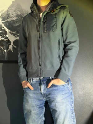  Parajumpers jacka - Snygg blå vindjacka från Parajumpers.  Personen på bilden är 177. Knappt använd. Köpt på nk ny pris 4700