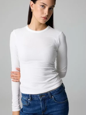 Vit långärmad topp - Klassisk vit långärmad topp med rund halsringning. sitter tight mot kroppen. Perfekt att styla med jeans eller kjol för en clean och enkel look. Prislappen kvar sälj för den var för liten. 71% Ekologisk bomull, 29% Polyamid