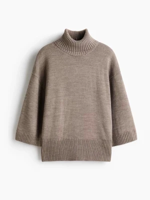 Beige stickad polotröja med halvlånga ärmar - Säljer en beige stickad polotröja med bred ribbad kant nedtill och vid ärmslut. Tröjan har halvlånga, lite vidare ärmar och hög polokrage. Perfekt för lager på lager och en chill look.