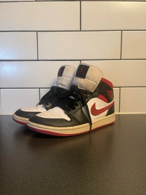 Air Jordan 1 Retro MID OG svart/röd - Säljer ett par Air Jordan 1 Retro mid OG sneakers från Nike. 