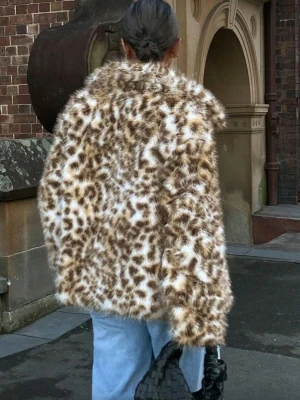 HELT NY & OANVÄND snygg Leopard fusk pälsjacka,  faux fur, M-L - HELT NY & OANVÄND supersnygg mjuk/len leopardmönstrad fuskpälsjacka med krage och långa ärmar, storlek Large men passar troligen även någon med Medium. Fickor. Satinfoder. Stängs med hakar. Helt felfri. Jackan har en cool och trendig look med svart, beige och bruna toner. Perfekt för dig som vill sticka ut och hålla dig varm under vintern. Slutsåld online och finns ej i fysisk butik.