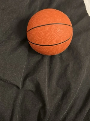 Orange basketboll med svarta linjer - En klassisk orange basketboll med svarta linjer och greppvänlig yta. Perfekt för spel både inomhus och utomhus. Tillverkad i slitstarkt gummi och har den traditionella bollenstrukturen.