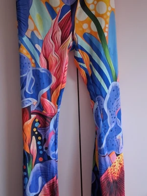 Färgglada leggings med abstrakt mönster - Säljer ett par leggings med färgstarkt abstrakt mönster i blått, gult, rött och grönt. De har hög midja och stretchigt material som sitter skönt. Perfekta för dig som vill sticka ut med din stil och älskar unika plagg!