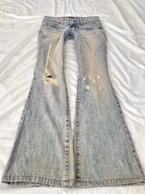 Vintage ljusblå bootcut jeans med slitningar - Sååå sjukt snygga superlågmidjade vintage jeans med slitna detaljer💓 midjemått: 38 cm Innebenslängd: 80 cm 