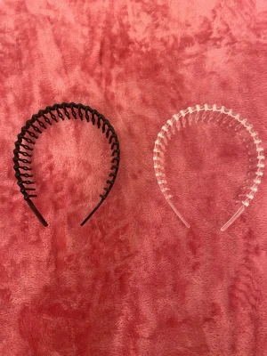 2-pack plastdiadem svart & transparent - Säljer två plastdiadem, ett svart och ett transparent. Båda har en vågig design med taggar som håller håret på plats. Perfekta för att få bort håret från ansiktet och ger en retro känsla till din look.
