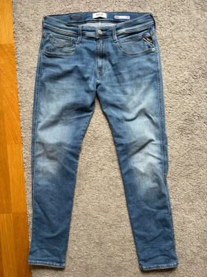 Blå slim fit jeans från Replay - Snygga ljusblå slim fit jeans från Replay.Jeansen har normal midja, dragkedjegylf och är tillverkade i mjuk denim med stretch för extra komfort. Hyperflex ( jeans nypris ca 1700 kr ) storlek W31 L32 använda fåtal gånger 