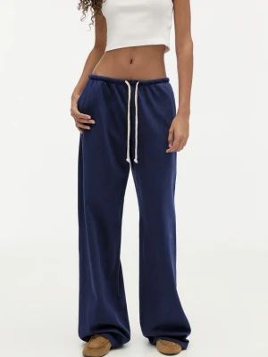 Mörkblå vida mjukisbyxor från Pull&Bear - Säljer ett par mörkblå mjukisbyxor med breda ben och vit dragsko i midjan. Byxorna har avslappnad passform och sidofickor. Passar nån som är ca 175cm