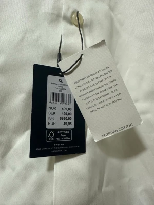 Vit kortärmad skjorta - Klassisk vit skjorta från Dressmann Premium med korta ärmar och bröstficka. Skjortan har knappar framtill och är tillverkad i ett slätt bomullstyg som känns fräscht och stilrent. Perfekt till sommarens alla tillfällen.