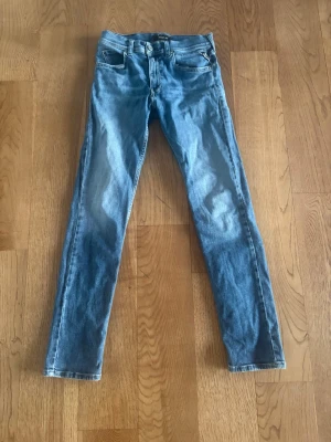 Replay jeans slim fit - Säljer ett par ljusblå slimfit jeans  från replay model är Wallys. Men har ett hål vid skrevet men är lagat syns knappt. Storlek är 14 år 