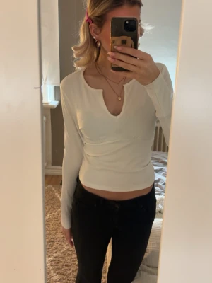Vit ribbad croppad långärmad topp - Säljer en vit, ribbad och croppad långärmad topp med unik v-ringad halsringning från only. Använd fåtal gånger men inga tecken på användning. Skriv om ni har frågor💕