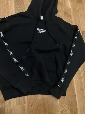 Reebok hoodie - Svart Reebok hoodie med design på armarna kom privat för frågor eller funderingar👍🏼