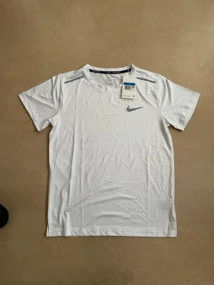 Nike miler T-shirt vit storlek medium  - Ny Nike t-shirt i stilren design. Perfekt basplagg till gym/vardag/sommar.  Oanvänd Populär modell Säljs snabbt  Skickas direkt 📦