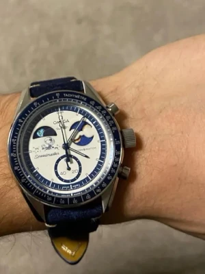 Omega x Swatch Speedmaster Moonwatch - Snygg Omega x Swatch Speedmaster Moonwatch med blått tygarmband och vit urtavla med blå detaljer. Klockan har tachymeter, kronograf och unika månmotiv på urtavlan. Perfekt för dig som gillar stilrena och ikoniska accessoarer.