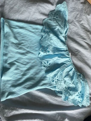 Ljusblå offshoulder topp med volang - Supersöt populär ljusblå offshoulder topp med bred volangkant i broderad spets från Zara. Toppen är ärmlös och har en ribbad kropp i mjuk bomullsmix. Storlek 164 men passar någon som har mellan XS-M. Så så fin och i ett väldigt bra skick❣️