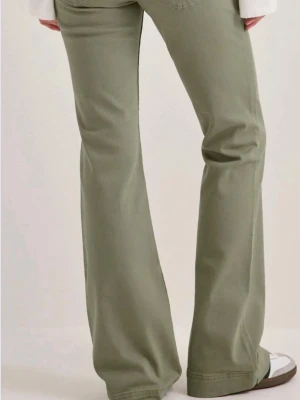Gröna bootcut jeans - Snygga gröna bootcut jeans med utsvängda ben och klassisk femficksdesign. Jeansen har en hög midja och är tillverkade i ett mjukt bomullsmaterial med lite stretch för extra komfort. Beställde hem olika storlekar för att prova. Finns i 36 och 40! Helt nya med prislapp och förpackning kvar! Nypris 599!