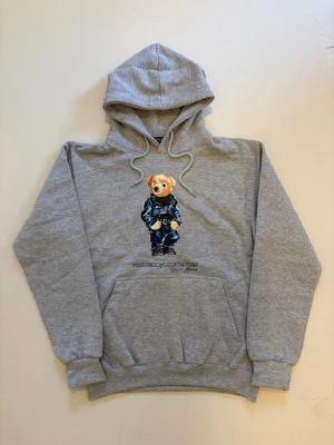 Grå Ralph lauren polo bear hoodie M - Grå Ralph Lauren Polo bear hoodie //  Mycket bra skick helt oanvänd //  Storlek M //  Mått  Längd  66cm Axelbredd 49cm Bredd under armhålorna 50cm armlängd 60cm // Skriv vid minsta fråga eller fundering🤝