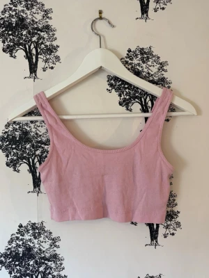 🌸Ljusrosa ribbad linnetopp🌸 - Snygg ljusrosa ribbad linnetopp med breda axelband och croppad passform. Perfekt att styla med jeans eller kjol för en chill look. Mjuk och stretchig i materialet för extra komfort!💓🌸