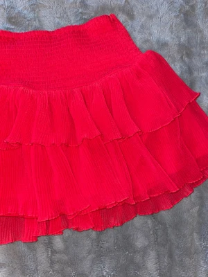 Röd volangkjol från Lindex - Supersöt röd kortkjol från Lindex. Passar på mig som vandligtvis har storlek xs. 