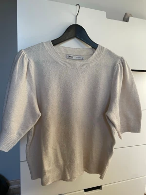 Beige stickad tröja från ONLY - Beige stickad tröja med kortare och lite puffiga ärmar från ONLY. Mjukt och inte sticksigt material. Passar till de mesta!