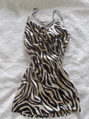 Zebra klänning - Så fin mönstrad klänning, den är öppen i ryggen och banden korsas i ryggen.