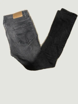 Svarta jeans från Tiger of Sweden - Snygga svarta jeans från Tiger of Sweden med klassisk femficksdesign och dragkedjegylf. Jeansen har en tvättad look. Tillverkade i mjuk bomullsdenim med lite stretch för extra komfort.