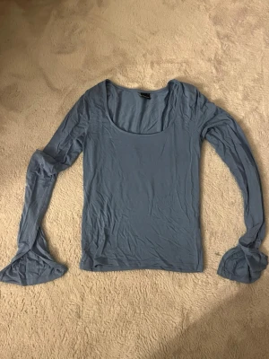 Blå tröja med slit - Säljer denna superfina blåa tröja från Gina med slit i ärmarna. Knappt använd, enda defekten är en söm som håller på att gå upp i höger arm (går lätt att sy ihop hemma)💞bara att höra av sig vid funderingar