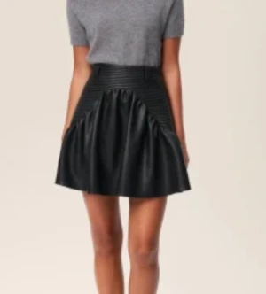 Svart kortkjol från Adoore i skinnlook - Säljer en svart kortkjol från Adoore med cool skinnlook och ribbad midja. Kjolen har en volangdetalj framtill och är tillverkad av polyuretan, bomull och polyester. Perfekt för dig som vill ha en edgy och trendig stil. Mer Strl.M än 40 tycker jag.