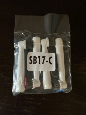 SB17-C borsthuvuden till eltandborste - Fyra vita borsthuvuden till eltandborste i plastpåse, märkta SB17-C. Borsthuvudena har olika färgmarkeringar i botten och svarta borst. Passar till eltandborstar med utbytbart huvud.