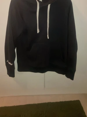 . - Säljer en svart hoodie från Russell Athletic. Klassisk modell med känguruficka och vit dragsko. Skön och bra kvalitet. Kan diskutera priset. Priset står inte fast i stål!!