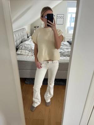 Vita bootcut jeans med broderi - Säljer ett par vita bootcut jeans med snyggt broderi på bakfickorna. Jeansen har klassisk femficksdesign och är tillverkade i ett mjukt denim-material. Perfekta för dig som vill ha en clean och stilren look.