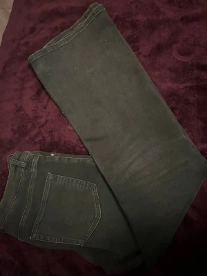 Svarta jeans från H&M, stl 42 - Säljer ett par svarta jeans från H&M i storlek 42. Klassisk femficksmodell med raka ben och normal midja. Jeansen är i stretchigt material som sitter snyggt och bekvämt. Perfekta till din vardagsstil!