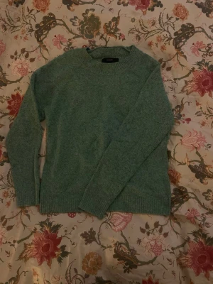 Grön stickad tröja med rund hals - Mysig grön stickad tröja med rund halsringning och långa ärmar. Tröjan är ifrån vero Moda och är i storlek S. Säljer då den inte kommit till användning, jättebra skick!